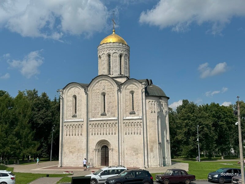 Белокаменный Дмитриевский собор во Владимире на фоне голубого неба Дмитриевский собор во Владимире — фасад с резьбой и золотым куполом
