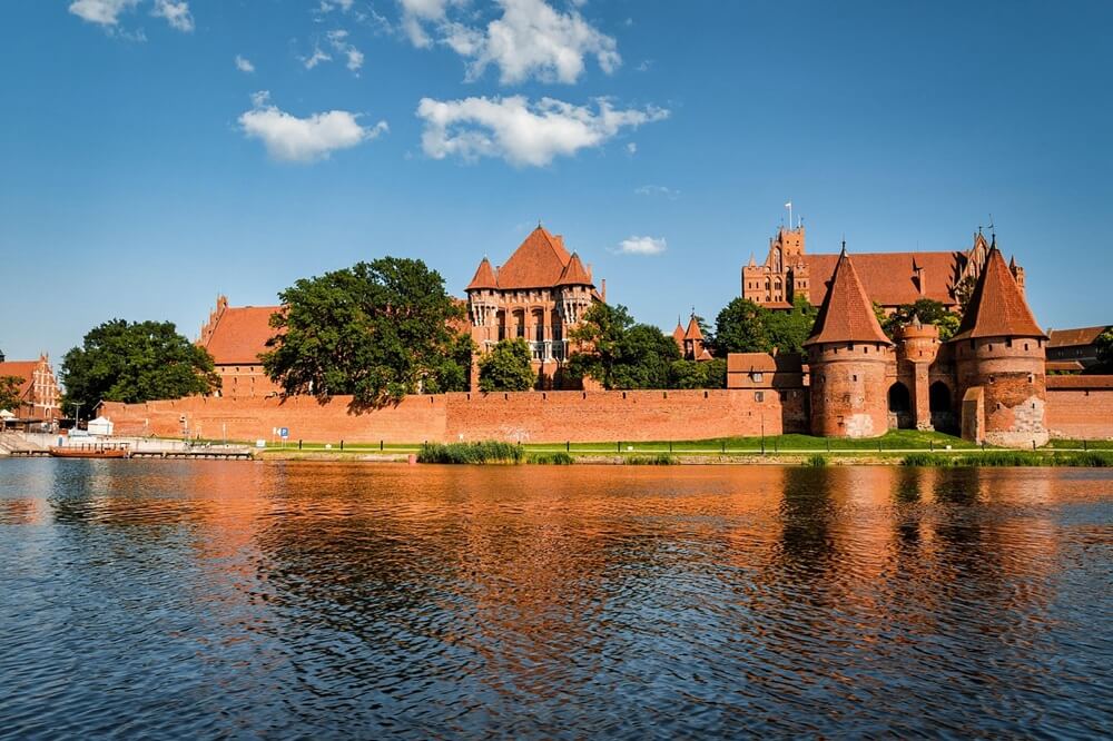 Замок Мальборк на берегу реки Ногат в солнечный день