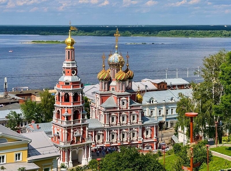 Вид на Строгановскую церковь и колокольню в Нижнем Новгороде с высоты, на фоне Волги и старинной городской застройки.