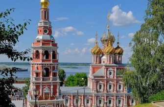 Строгановская церковь и колокольня на фоне Оки в Нижнем Новгороде, яркий пример русского барокко с разноцветными куполами и классической звонницей.