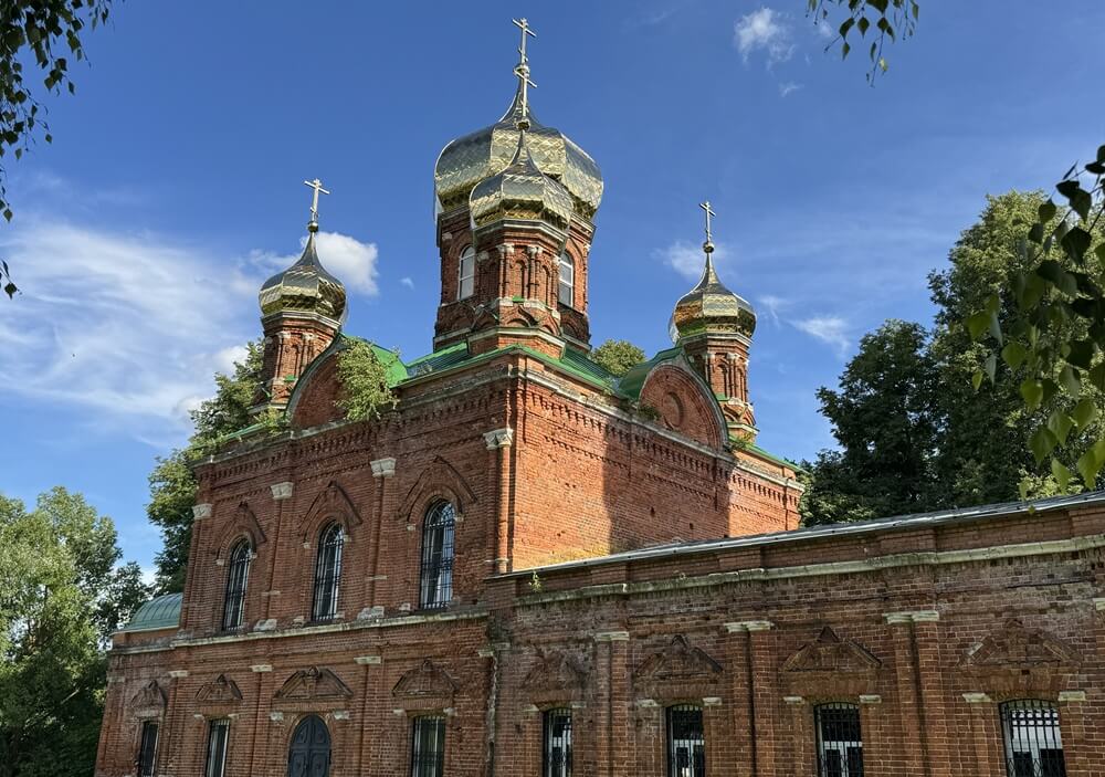Купола и кирпичный фасад храма Всех Святых в селе Ивановское под Чеховом